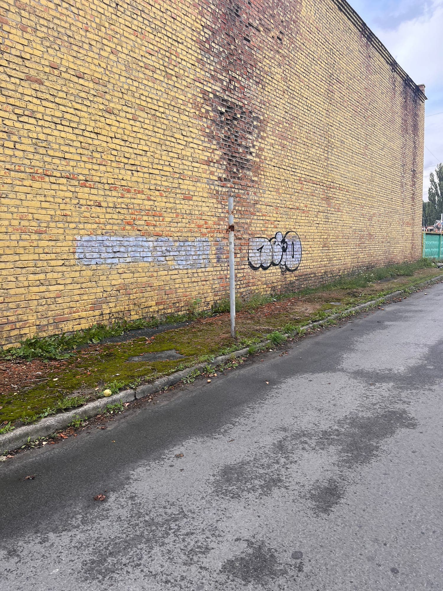 Edge of the carriageway, abutting the wall