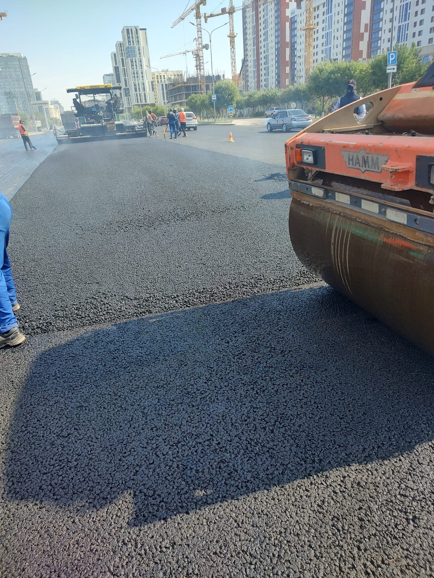 Hamm roller compacting the freshly laid course on Mangilik El Avenue