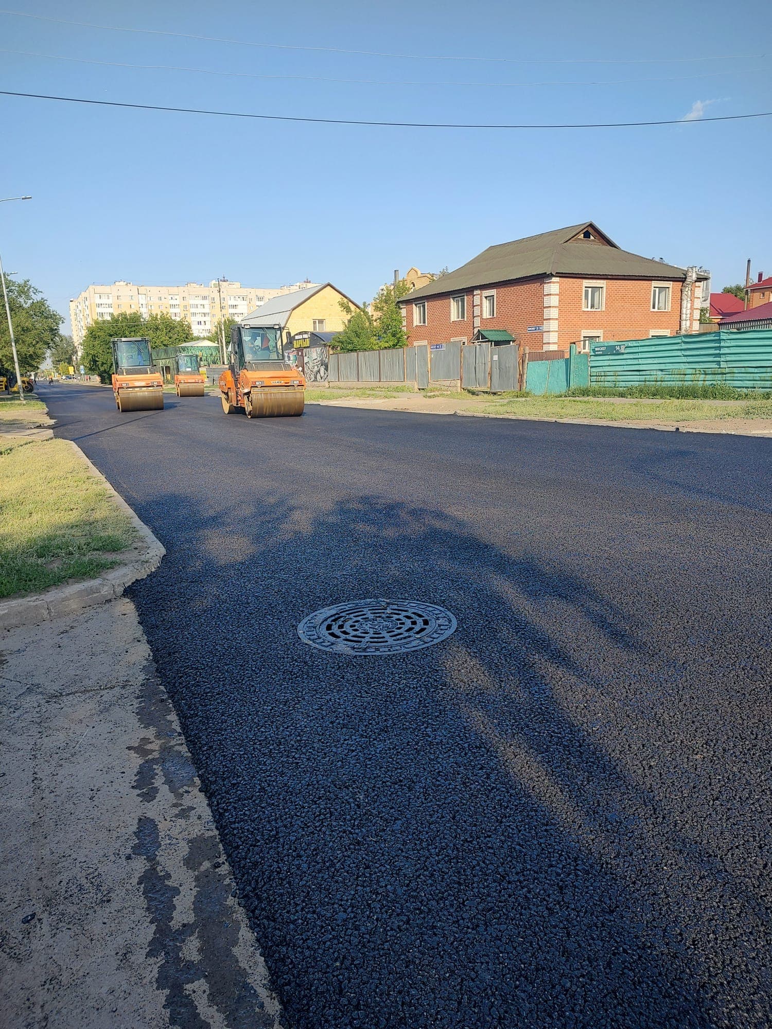 Finished pavement of Moskovskaya Street with a manhole after paving