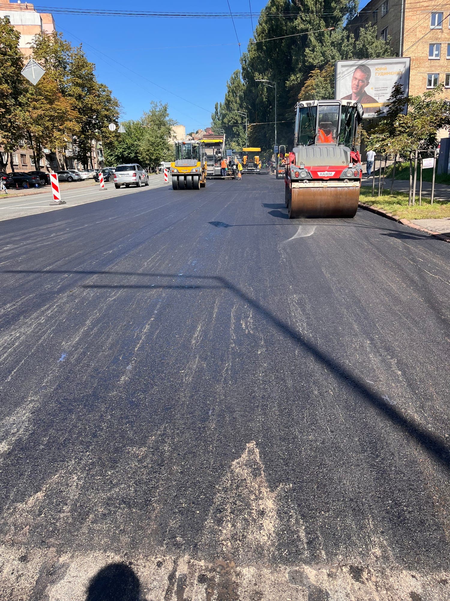 Roller compacting the fresh MZ A-20 course on Mykhaila Boichuka Street