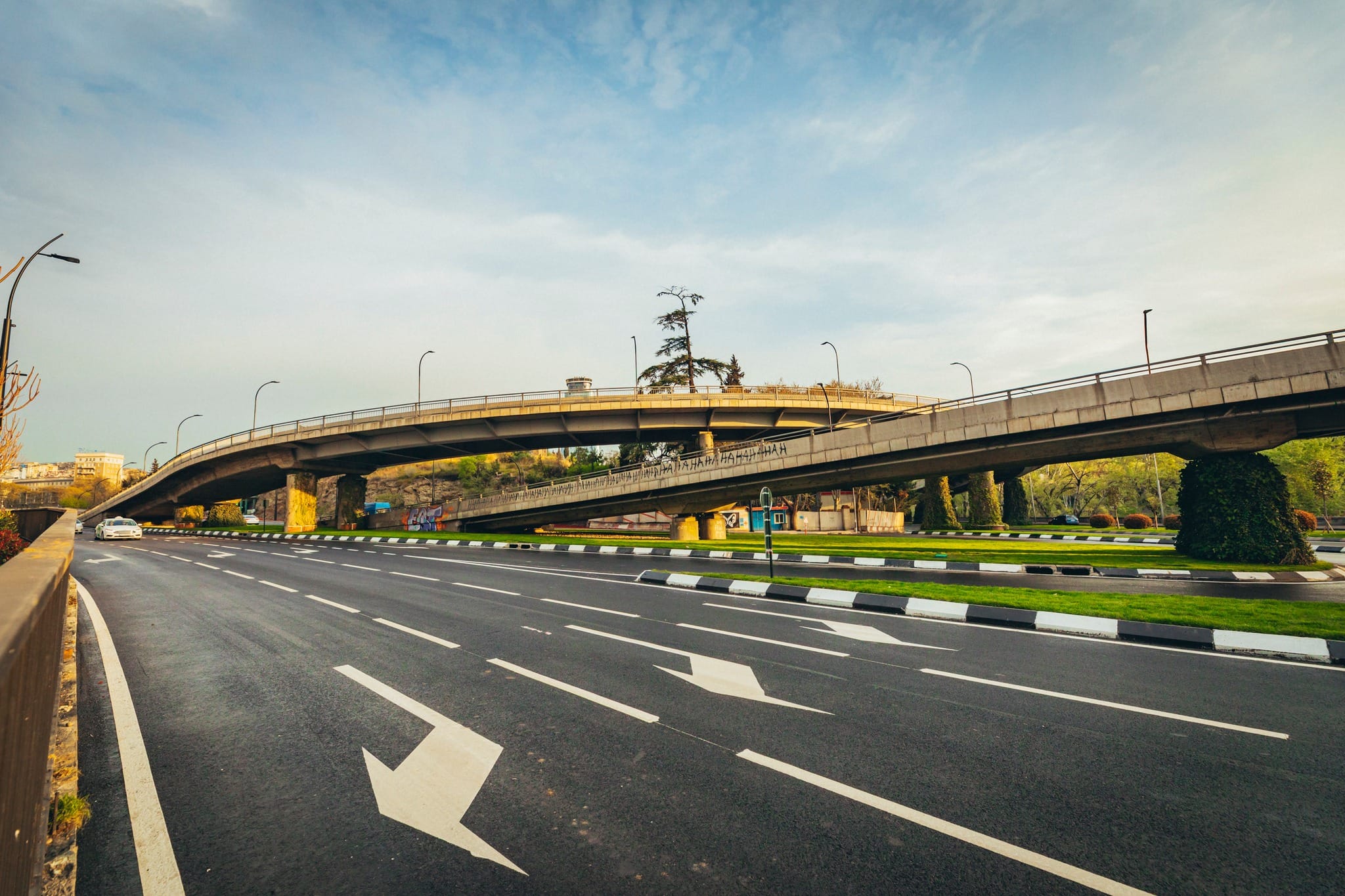 Une chaussée à plusieurs voies au marquage neuf sous un viaduc