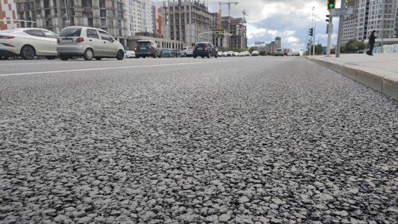 La textura del pavimento terminado en primer plano, una calle detrás