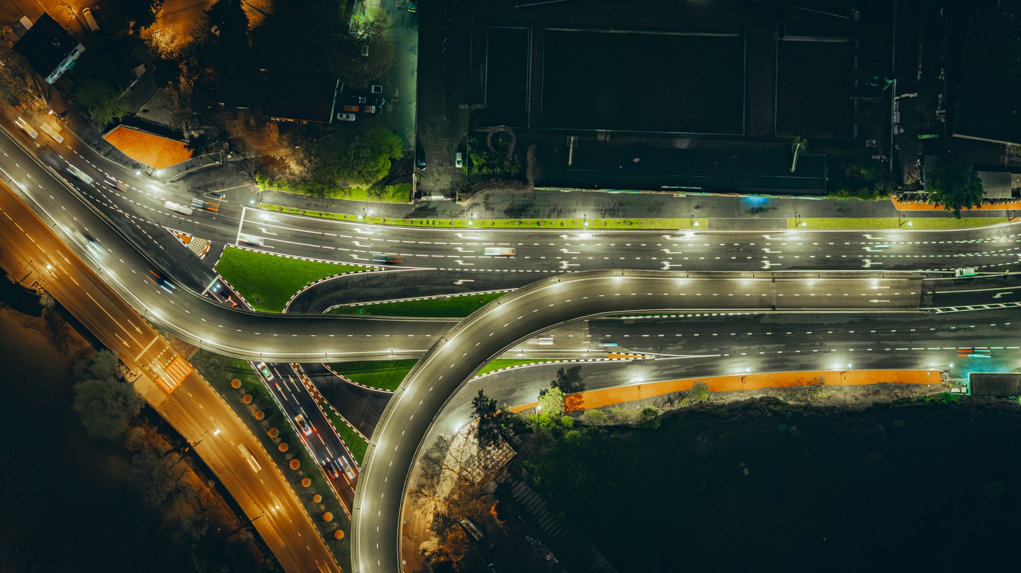 An interchange at night from above: lit lanes and slip roads